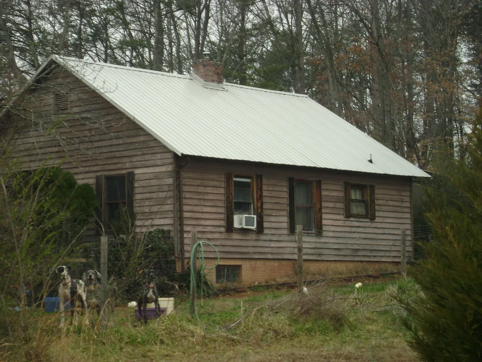 White metal roof on an old wood sided farmhouse, from a Metal Roof Installation job in Silver City